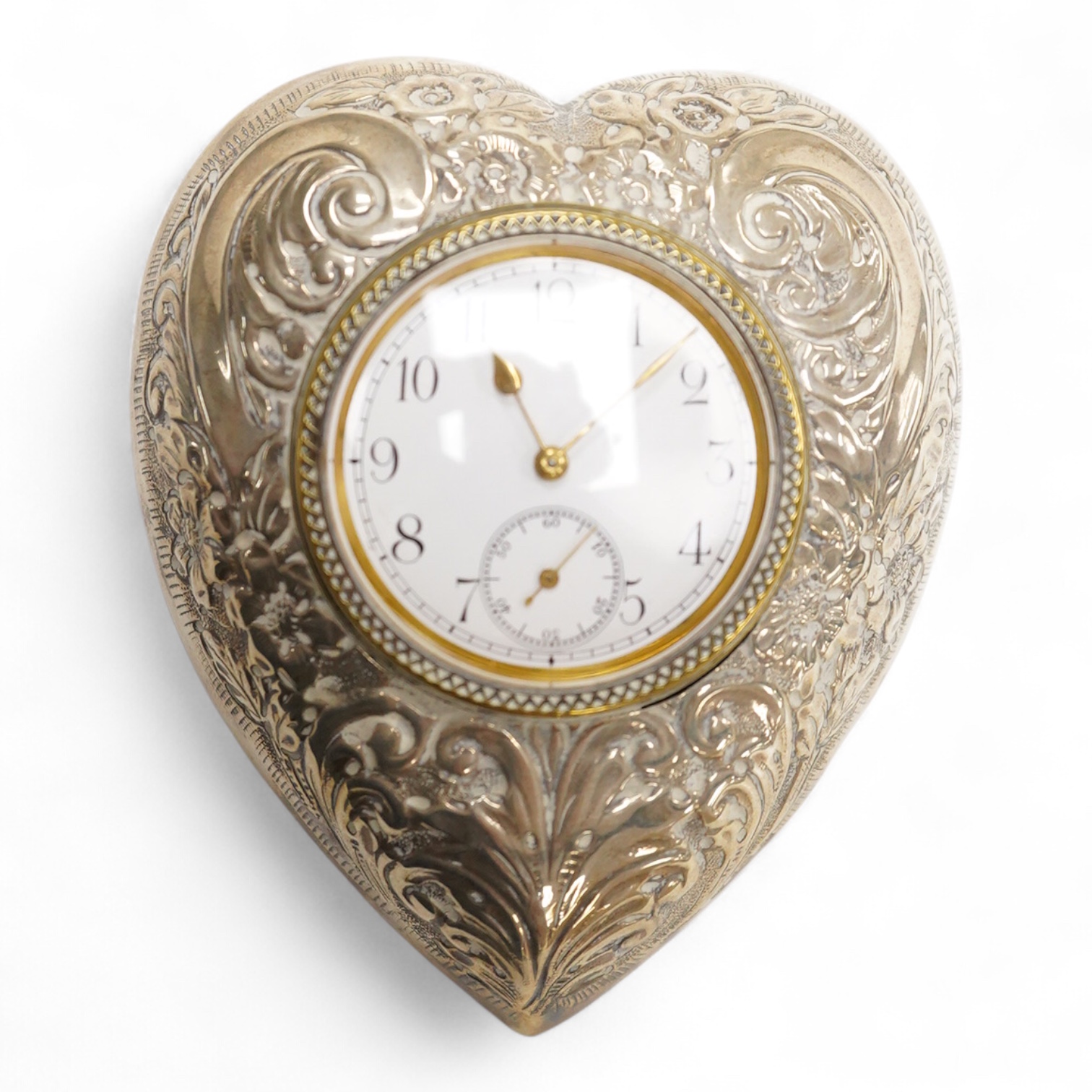 A late Victorian repousse silver mounted brass heart shaped bedside timepiece, with Arabic dial and subsidiary seconds, Douglas Clock Co. Birmingham, 1900, 94mm.